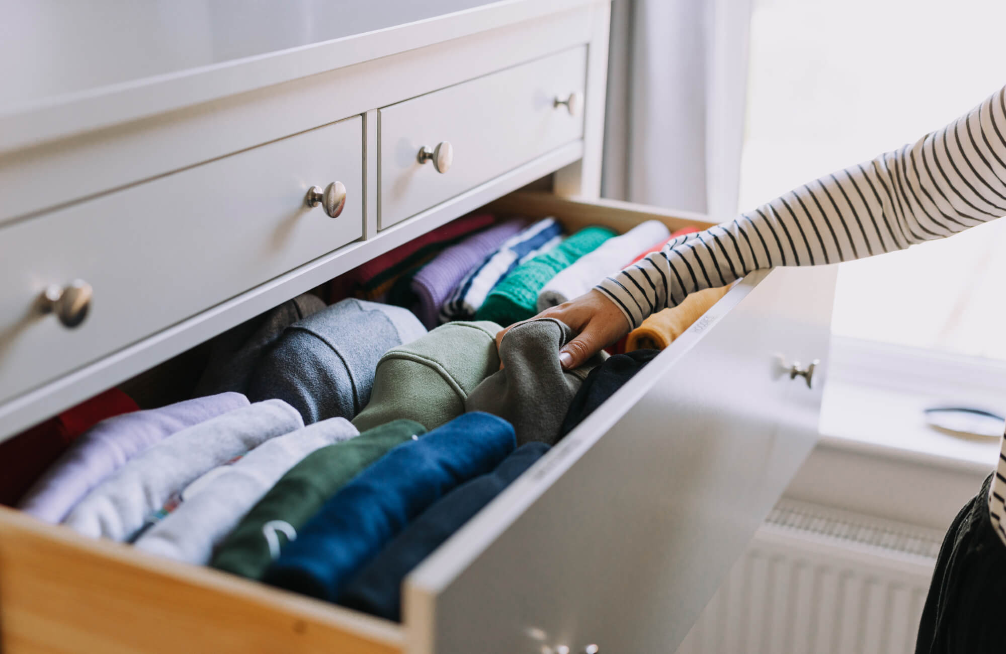 Sarah sorting clothes in drawers